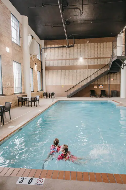 Two kids swimming in the indoor pool at the Waterfront Plaza building in Canal Park